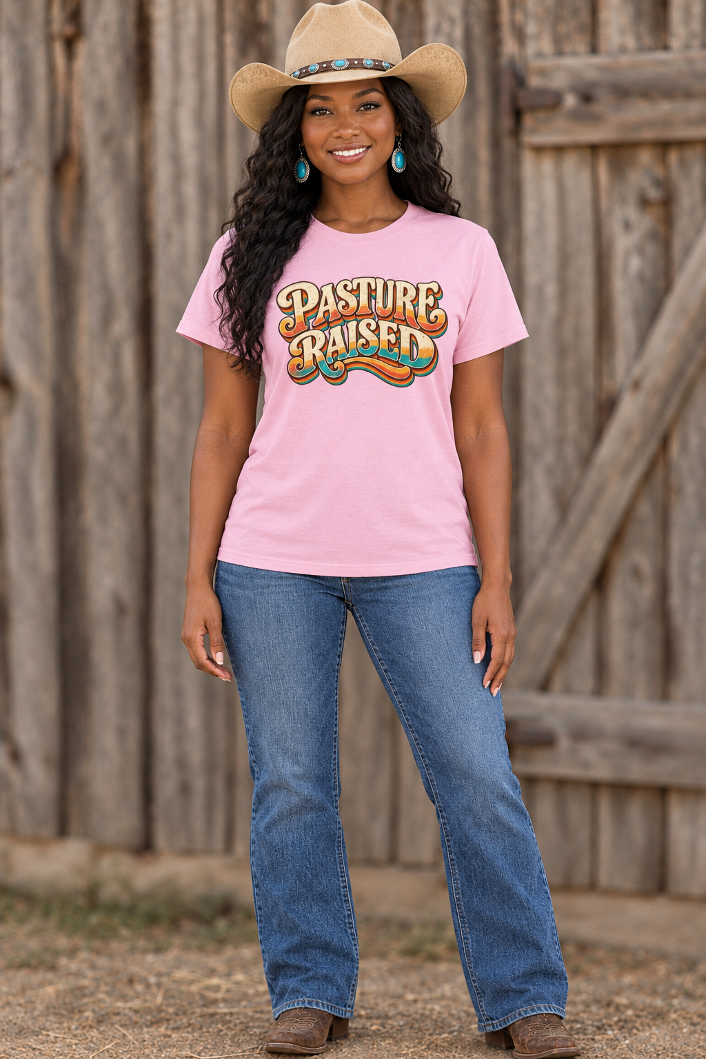 Black cowgirl wearing the pink Pasture Raised tee against a rustic barn backdrop