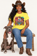 Black cowgirl wearing the yellow Bad Hens Club tee seated beside a pit bull