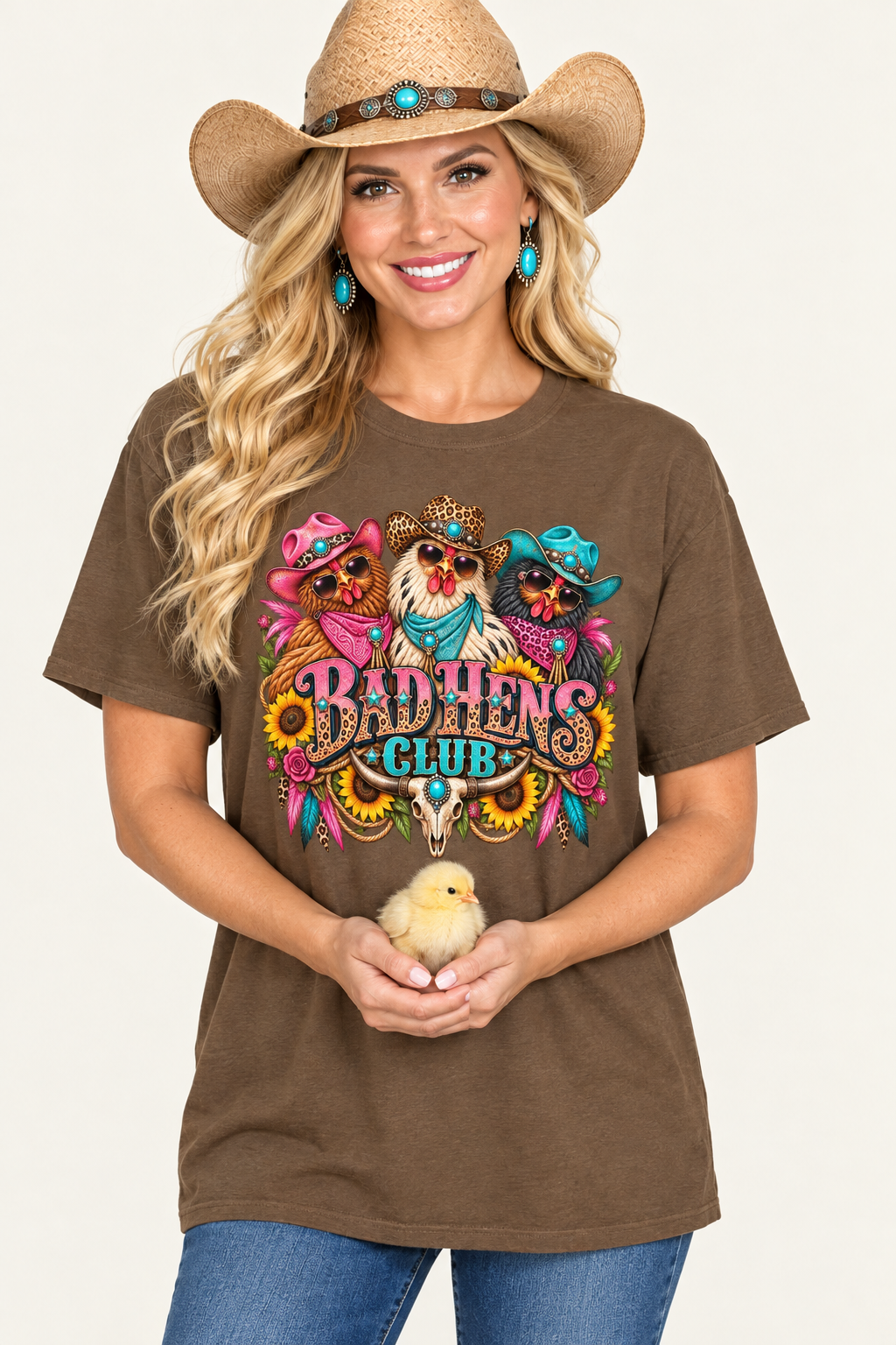 Cowgirl in an oversized saddle-brown Bad Hens Club tee holding a baby chick under soft studio lighting