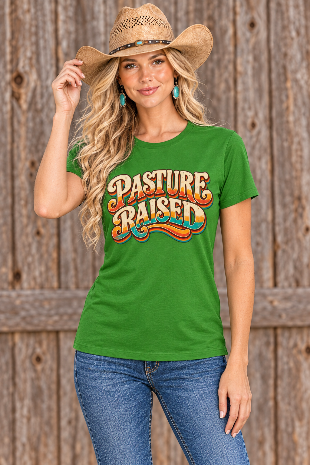 Same blonde cowgirl in the green Pasture Raised tee with a new hat-brim pose against barn wood